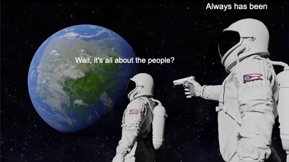 The "always has been" meme. Two astornauts are in space. One in the background is looking at Earth, saying "Wait, it's all about the peopl". The other one points a gun to his back, saying "Always has been".