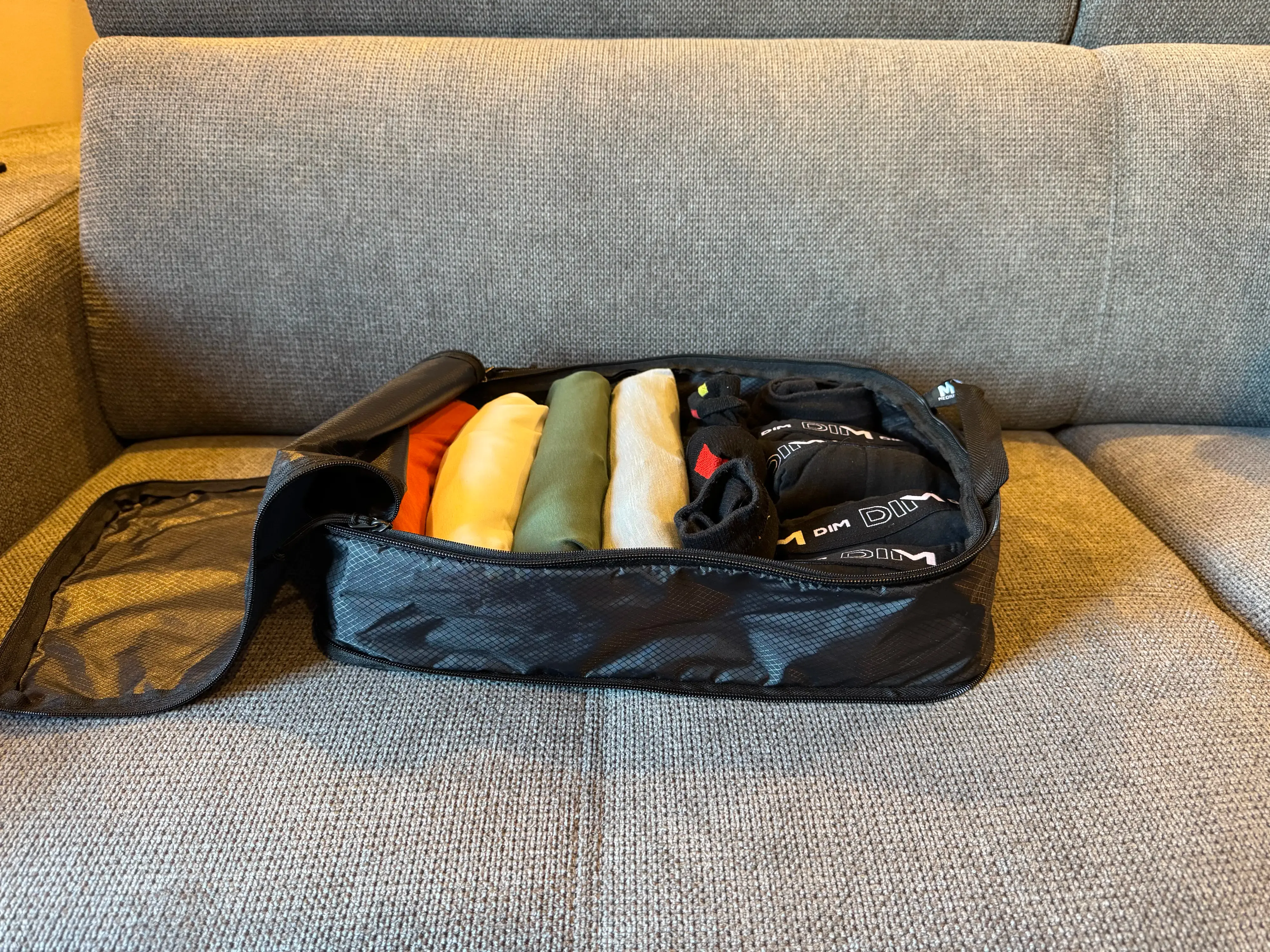 A photo of a compression cube full of clothes. It contains 4 t-shirts, 4 boxers and 4 pair of socks.