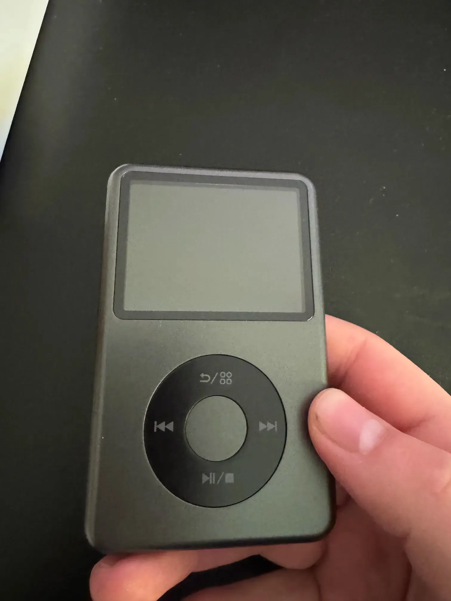 A photo of a portable music player that resembles a tiny iPod Classic.